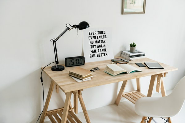 A wooden desk set up with notebooks to plan career goals