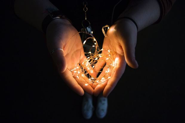 Hands holding an inspirational string of lights
