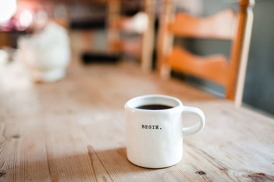Coffee mug on wooden table that says 