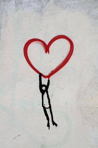 A graffiti painting of a person holding onto a heart to keep empathy and compassion